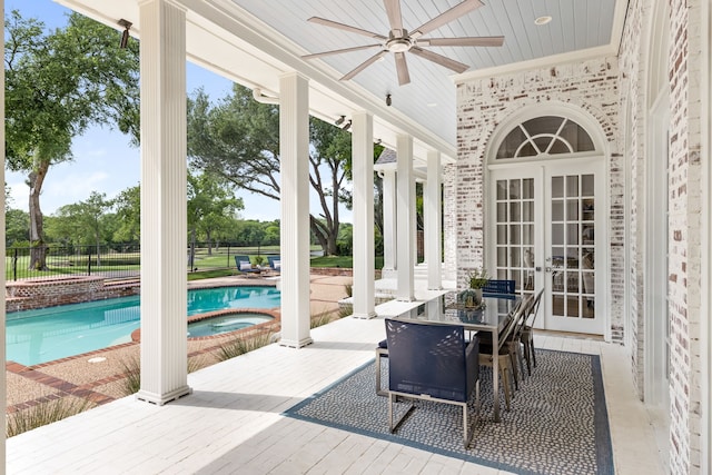 exterior space with a hot tub, french doors, and a pool