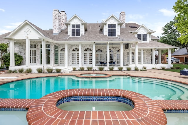 view of swimming pool featuring french doors, a patio, and a pool with connected hot tub