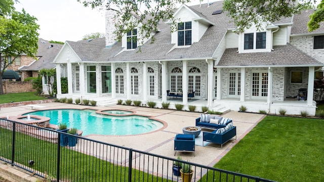 view of swimming pool featuring french doors, an outdoor living space with a fire pit, a patio, and a lawn