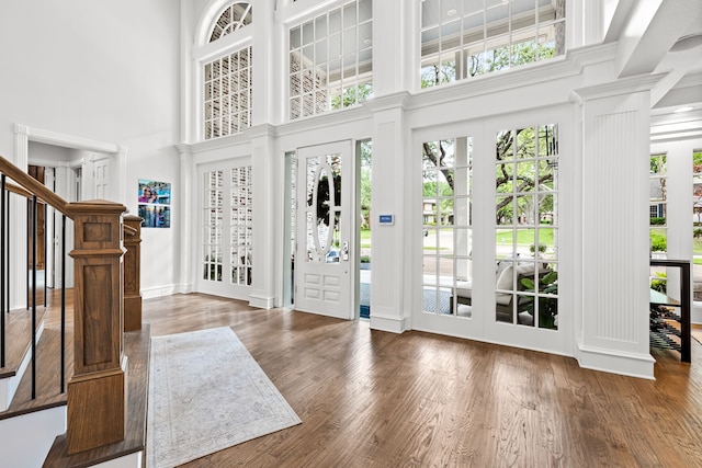 foyer with stairway, a high ceiling, and wood finished floors