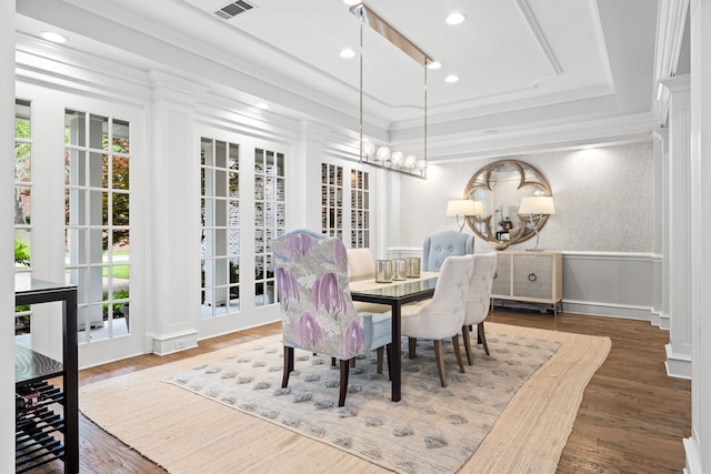 dining space featuring a healthy amount of sunlight, ornamental molding, a tray ceiling, and a notable chandelier