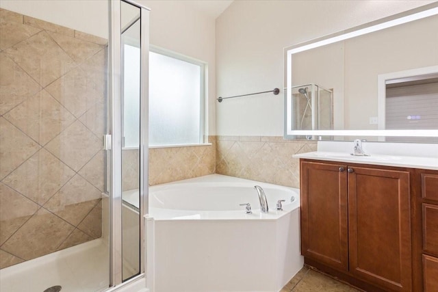 bathroom with a garden tub, tile patterned flooring, a stall shower, and vanity