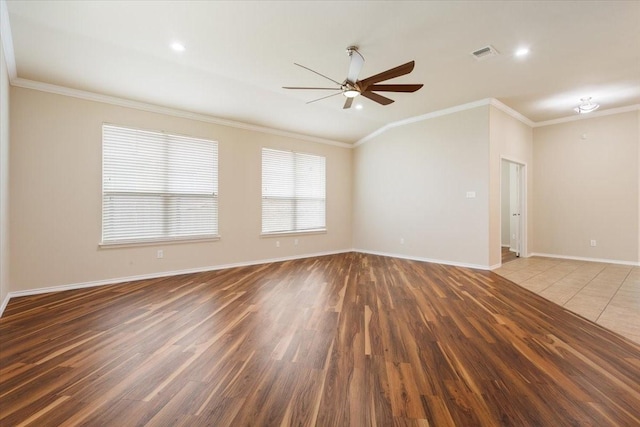 unfurnished room with ceiling fan, baseboards, wood finished floors, visible vents, and ornamental molding