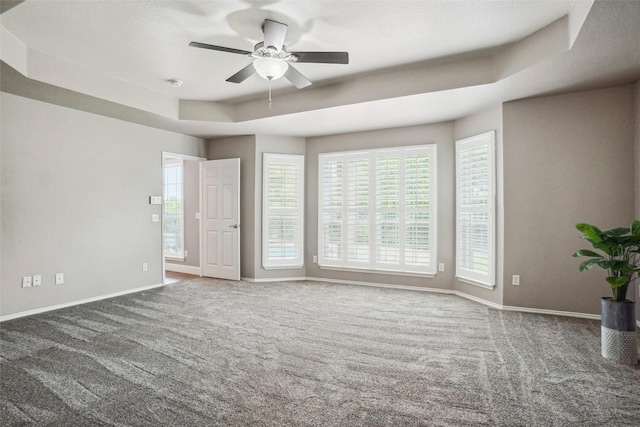 spare room with carpet flooring, a ceiling fan, and baseboards