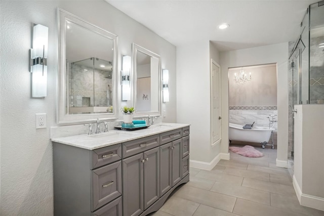 bathroom with tile patterned flooring, a sink, a stall shower, and a notable chandelier