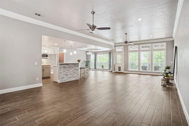 living area with baseboards, ornamental molding, dark wood finished floors, and visible vents