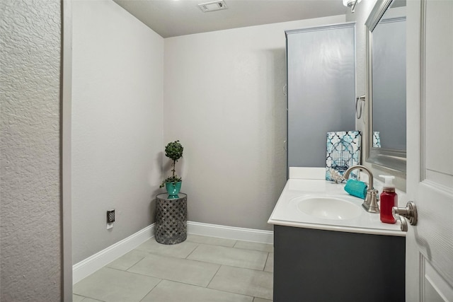 bathroom featuring baseboards, visible vents, tile patterned flooring, and vanity