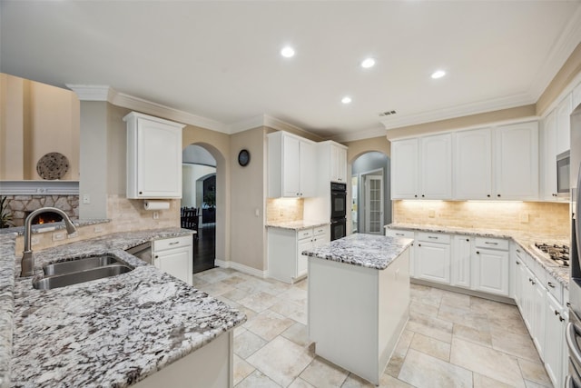 kitchen featuring arched walkways, dobule oven black, decorative backsplash, and a sink