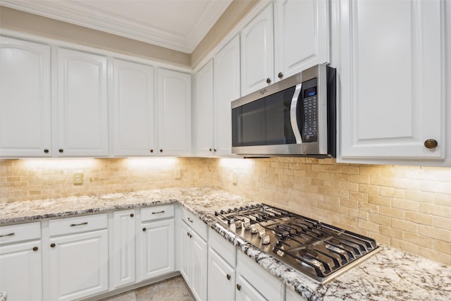 kitchen with crown molding, decorative backsplash, white cabinets, and stainless steel appliances
