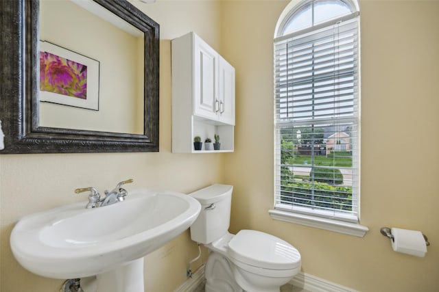 bathroom with baseboards, a sink, and toilet