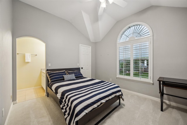 bedroom featuring connected bathroom, light colored carpet, a ceiling fan, baseboards, and lofted ceiling