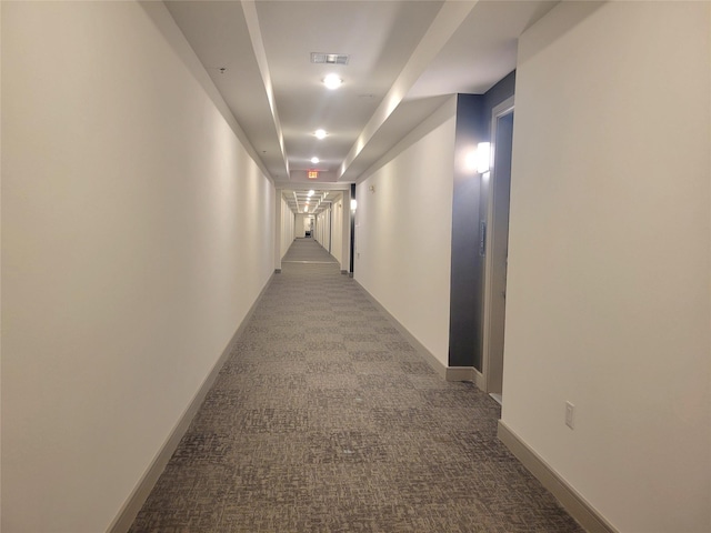 hall with carpet flooring, baseboards, and visible vents