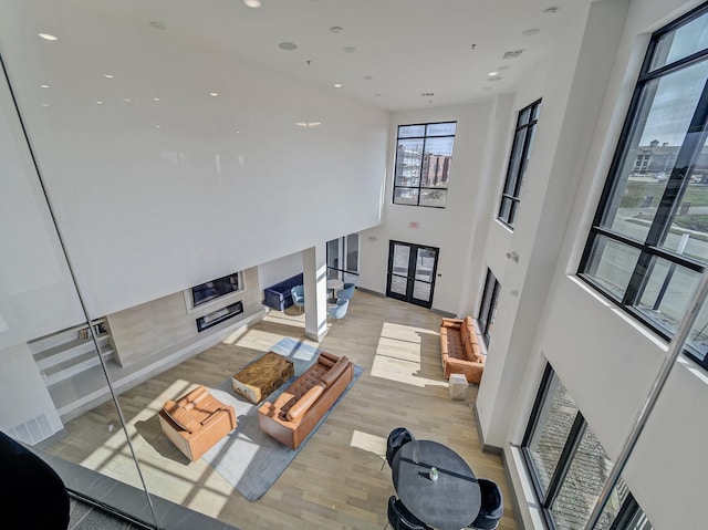 living area with recessed lighting, a fireplace, and light wood-type flooring