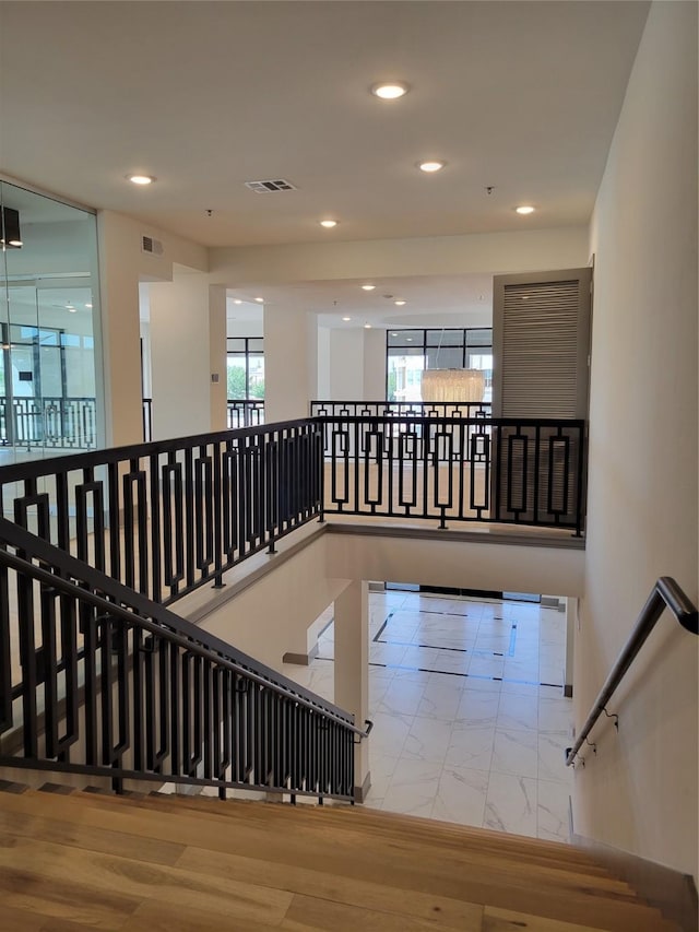 staircase featuring recessed lighting, visible vents, and marble finish floor
