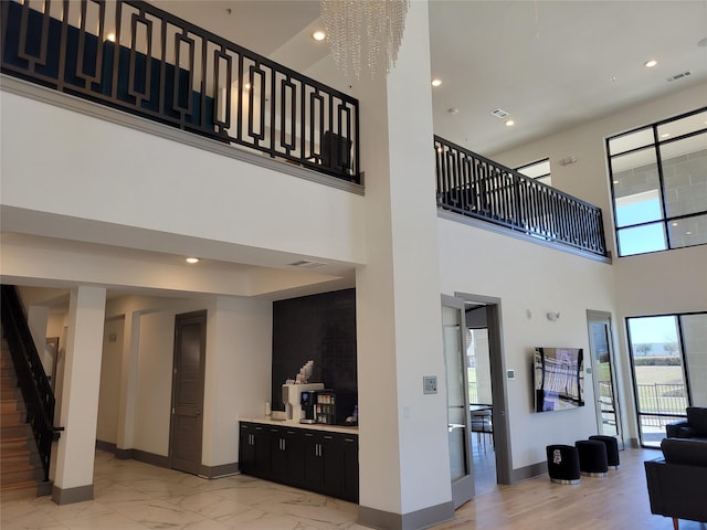 living area with stairway, baseboards, plenty of natural light, and visible vents