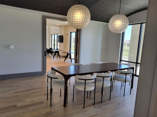 dining space featuring baseboards and light wood-style flooring