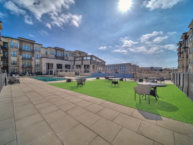 view of community with a yard, fence, and a pool