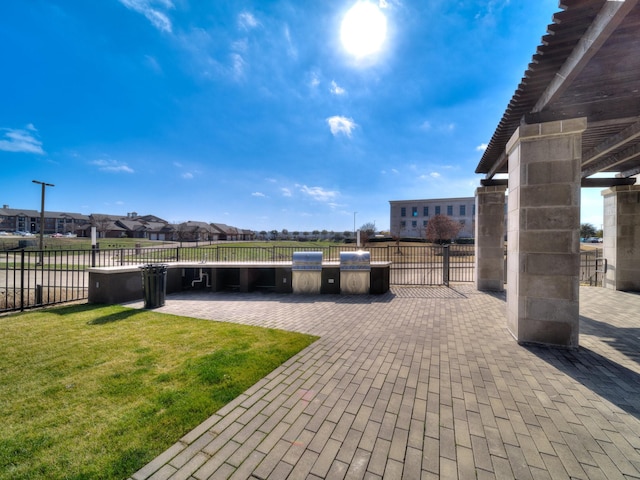 view of patio with fence, a residential view, and a grill