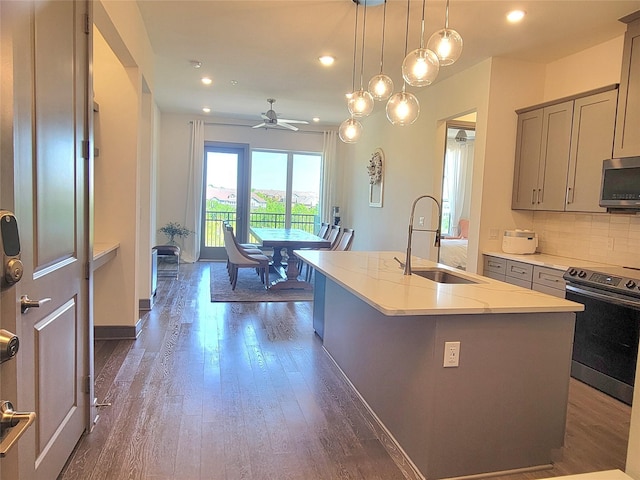 kitchen featuring a sink, dark wood-style flooring, gray cabinets, a ceiling fan, and stainless steel appliances