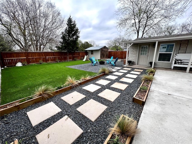 view of yard with an outdoor structure, a fire pit, a patio, a fenced backyard, and a storage shed