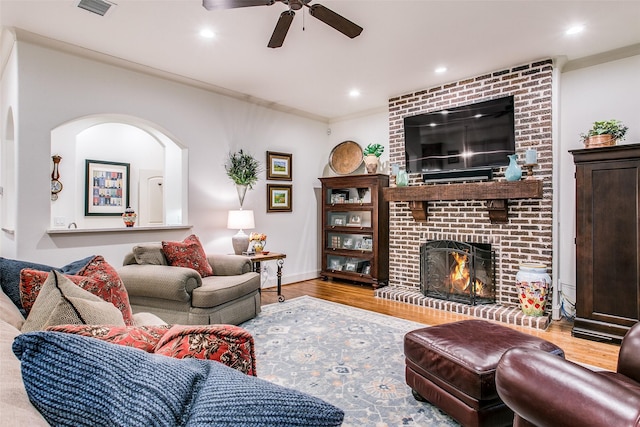 living room featuring visible vents, wood finished floors, a fireplace, ceiling fan, and recessed lighting