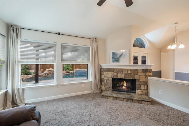 unfurnished living room featuring carpet, a fireplace, lofted ceiling, ceiling fan, and a chandelier