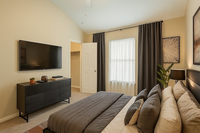 office space with vaulted ceiling, light colored carpet, baseboards, and a ceiling fan