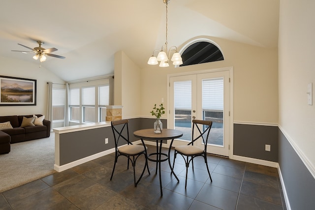 dining area featuring vaulted ceiling, baseboards, a ceiling fan, a chandelier, and french doors