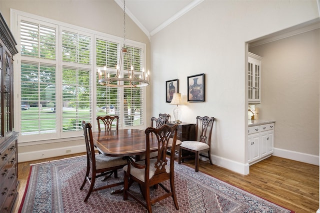 dining space featuring plenty of natural light, ornamental molding, vaulted ceiling, and a chandelier
