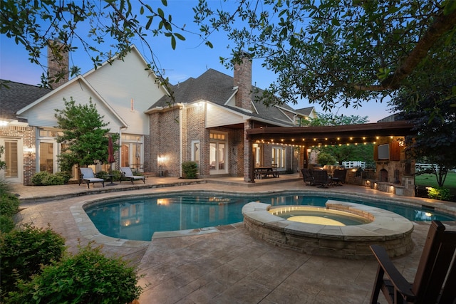 view of pool with a patio and a pool with connected hot tub