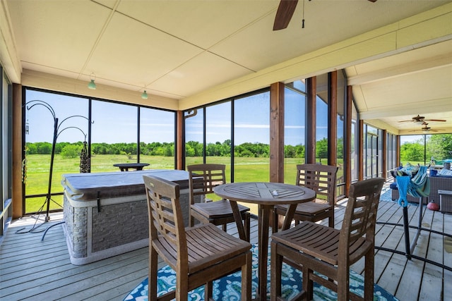 sunroom / solarium with a ceiling fan and outdoor dining space