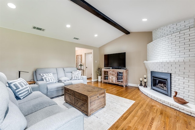 10907 Wonderland Trl, Dallas, TX 75229 - living area with visible vents, lofted ceiling with beams, light wood-style floors, and a brick fireplace
