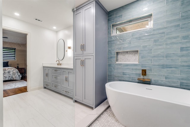10907 Wonderland Trl, Dallas, TX 75229 - ensuite bathroom featuring visible vents, a freestanding tub, tile walls, vanity, and connected bathroom