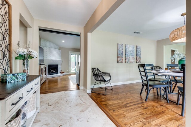 10907 Wonderland Trl, Dallas, TX 75229 - dining room with visible vents, baseboards, light wood finished floors, and a fireplace