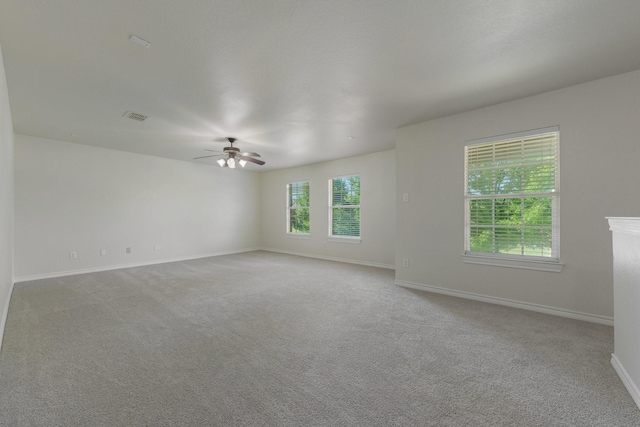 unfurnished room featuring baseboards, a ceiling fan, carpet flooring, and visible vents