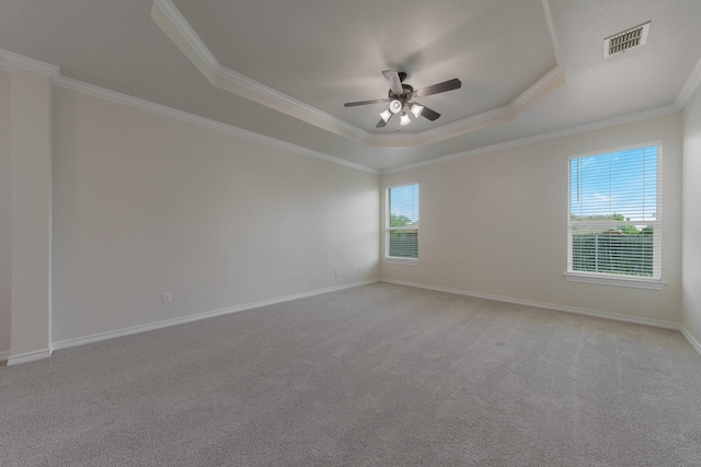 spare room featuring crown molding, a ceiling fan, a tray ceiling, and visible vents
