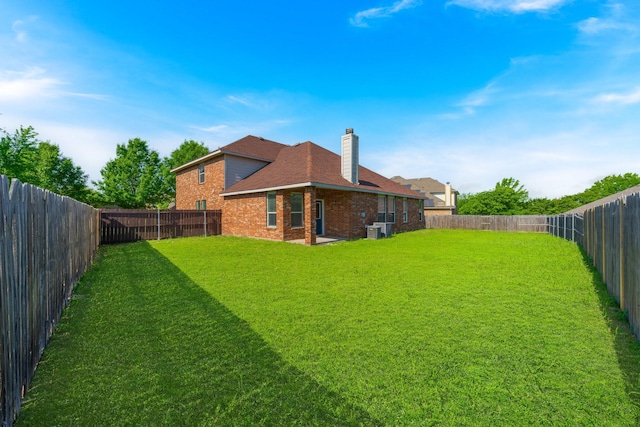 view of yard with a fenced backyard and central AC