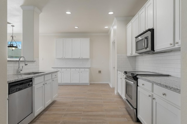 kitchen featuring a sink, appliances with stainless steel finishes, ornamental molding, and tasteful backsplash