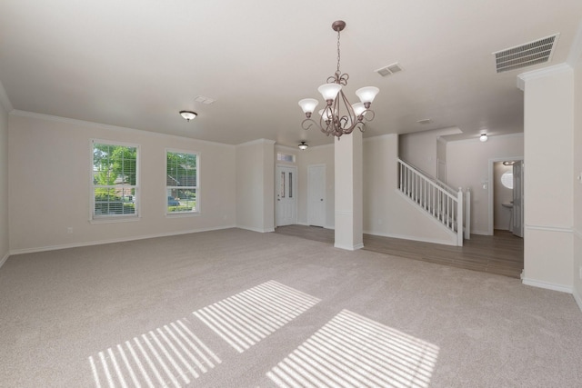 unfurnished living room featuring light colored carpet, a notable chandelier, visible vents, and baseboards