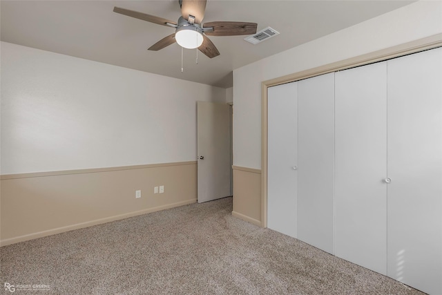 unfurnished bedroom featuring ceiling fan, carpet floors, baseboards, visible vents, and a closet