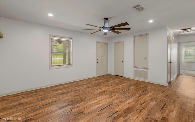 unfurnished bedroom with light wood-style floors, multiple windows, and visible vents