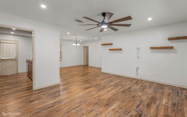 spare room featuring visible vents, wood finished floors, baseboards, recessed lighting, and ceiling fan with notable chandelier