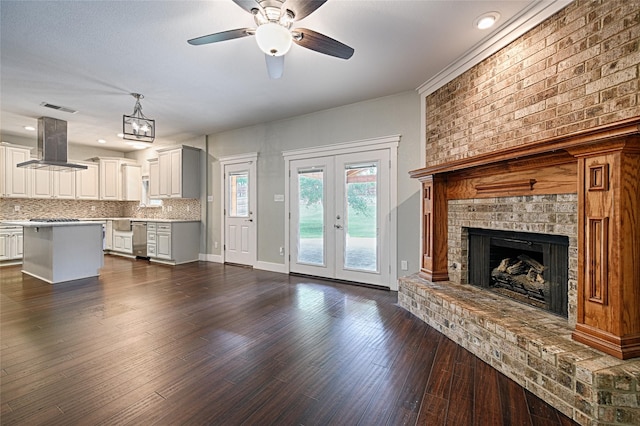 2620 Argyle Shore Dr, Rockwall, TX 75087 - unfurnished living room featuring ceiling fan, french doors, visible vents, a brick fireplace, and dark wood-style floors