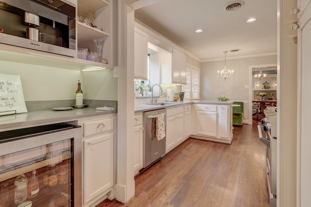 bar with visible vents, crown molding, a sink, beverage cooler, and stainless steel appliances