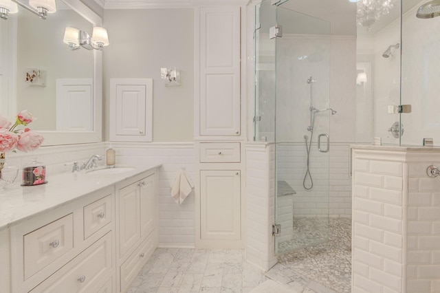 bathroom featuring crown molding, wainscoting, a shower stall, vanity, and marble finish floor