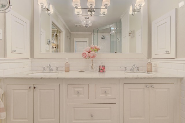 bathroom featuring a sink, a shower stall, double vanity, and a notable chandelier