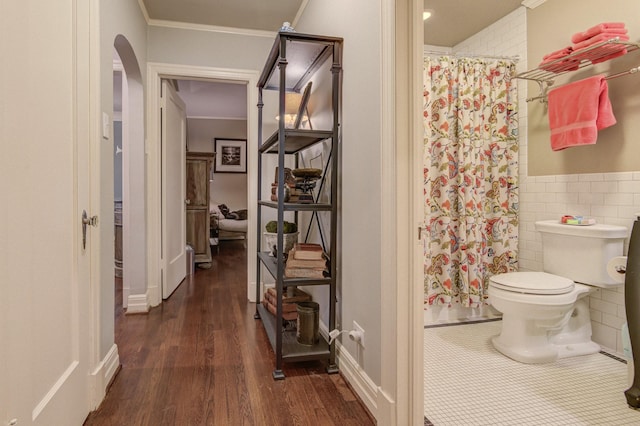 full bathroom featuring toilet, tile walls, ornamental molding, and a shower with shower curtain