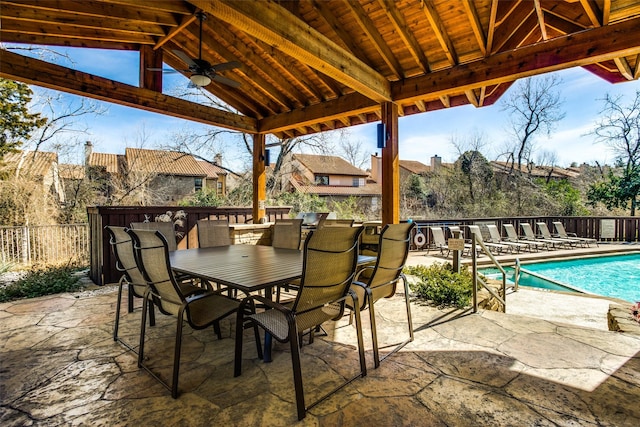 view of patio / terrace with fence, a gazebo, a fenced in pool, outdoor dining area, and a ceiling fan