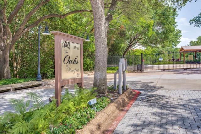 community / neighborhood sign featuring fence