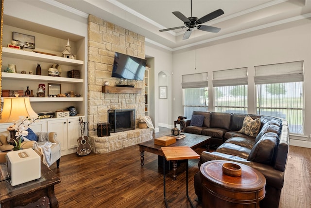 living area with crown molding, dark wood finished floors, ceiling fan, and a healthy amount of sunlight